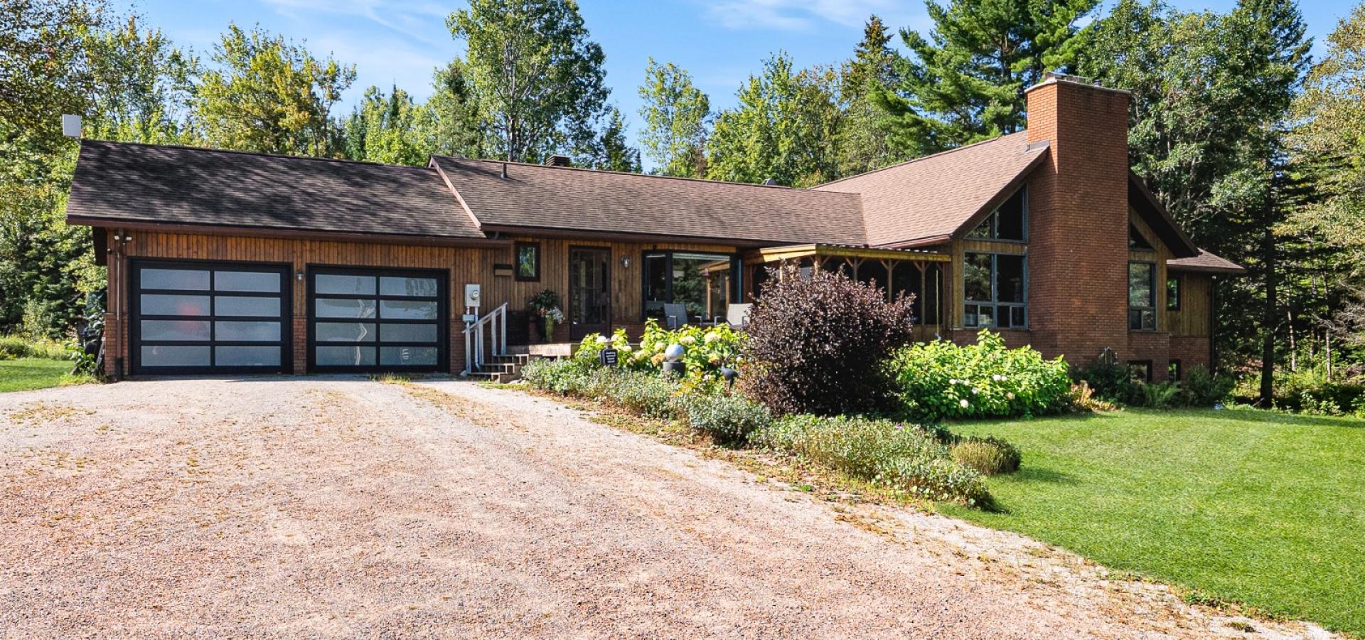 brown house with 2 glass panel garage doors