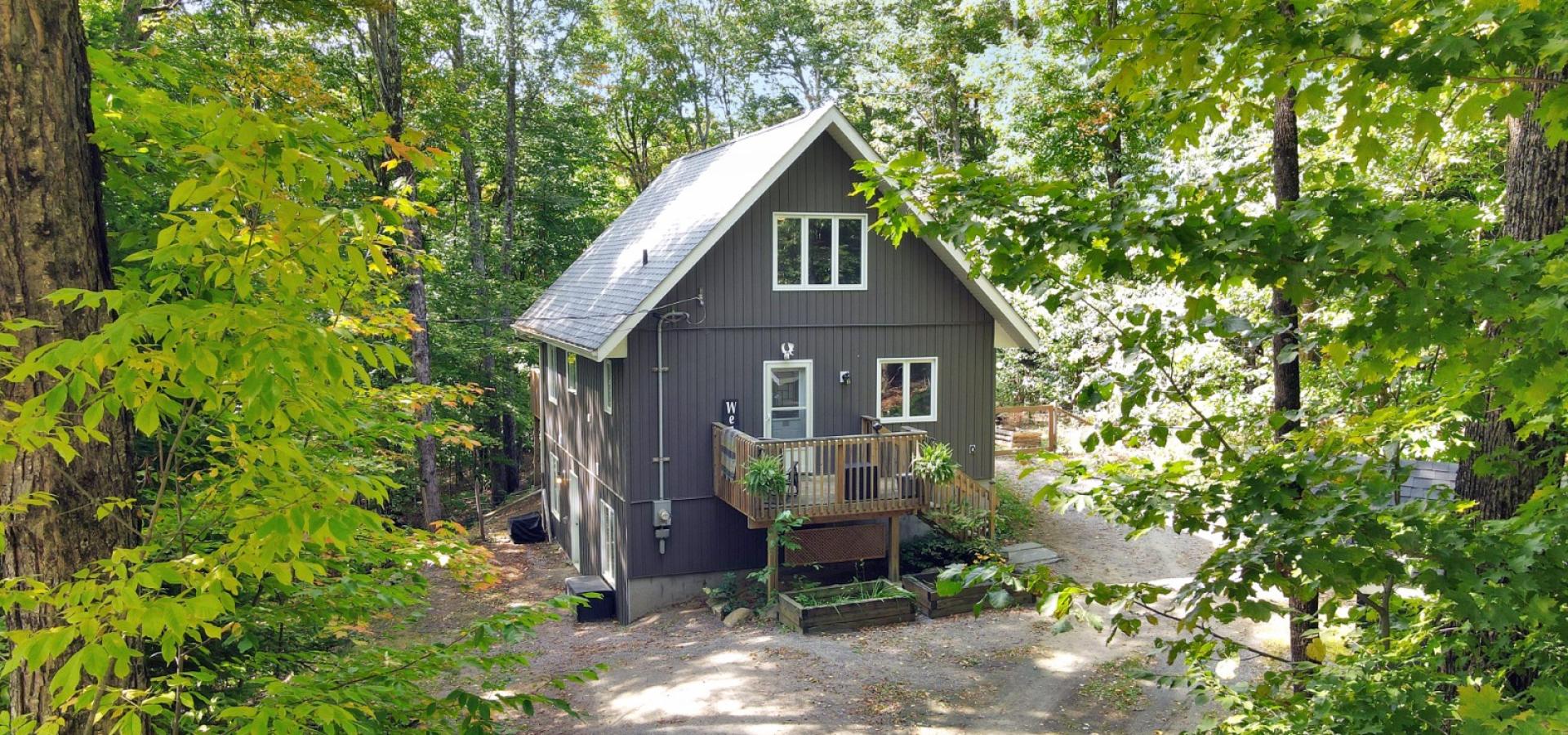 Great house with wood front porch and gravel parking.