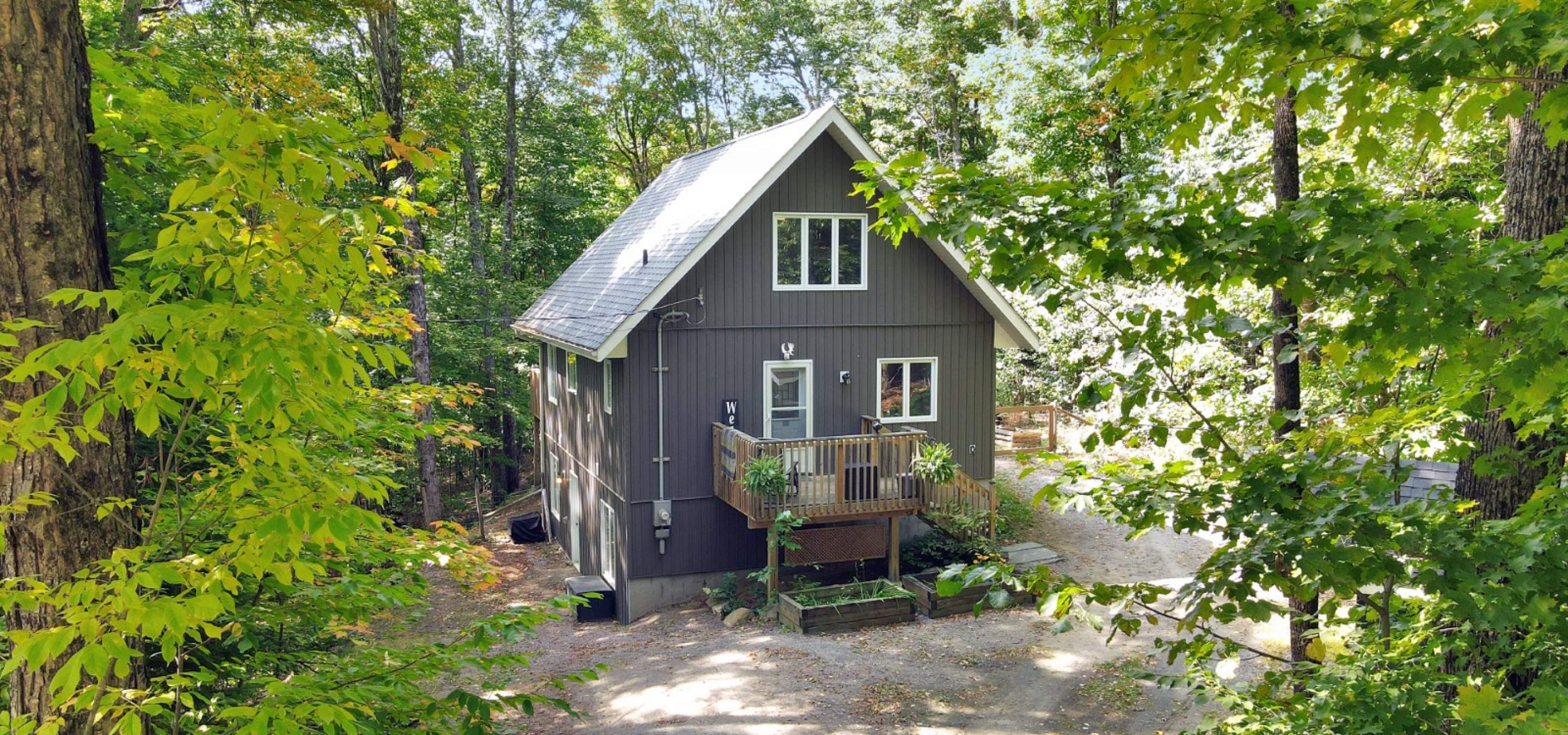 Great house with wood front porch and gravel parking.