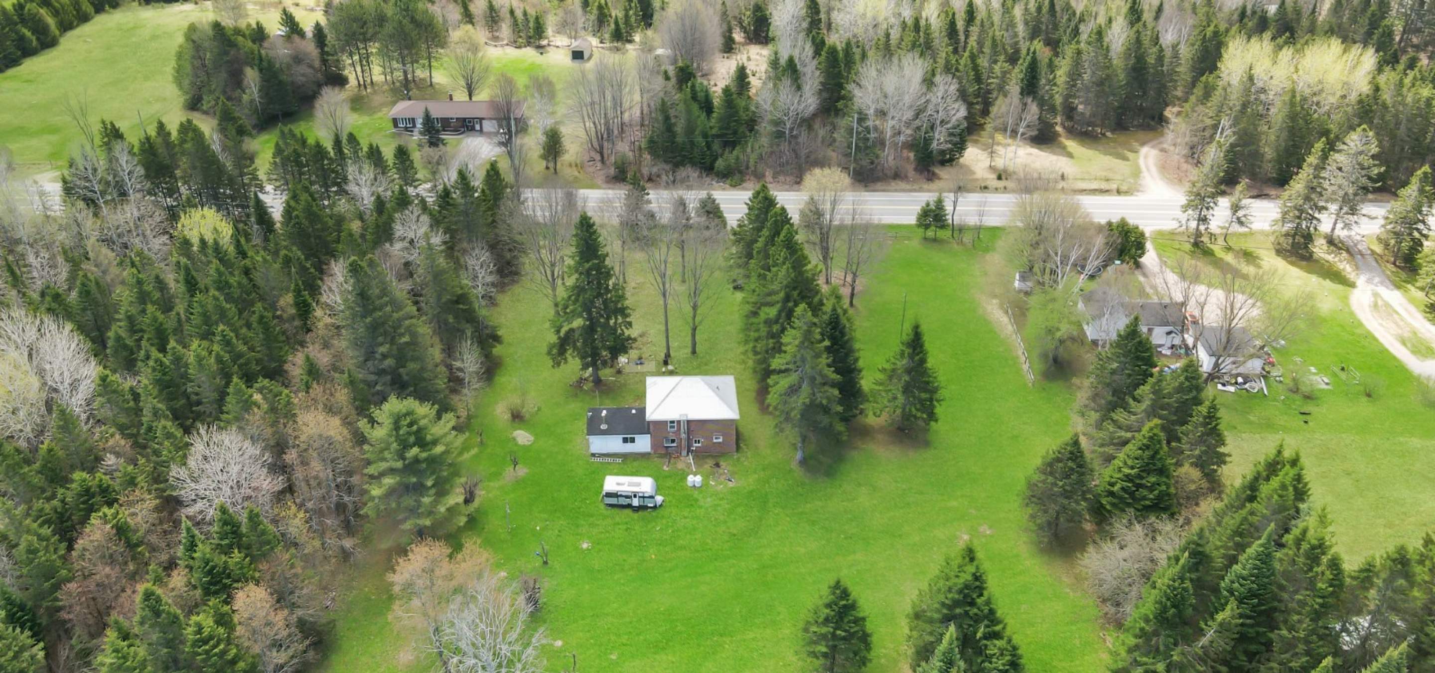 aerial view of a property with green grass and tress around. 