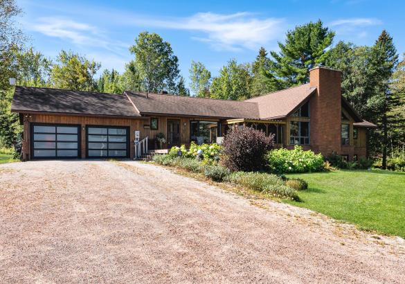 brown house with 2 glass panel garage doors