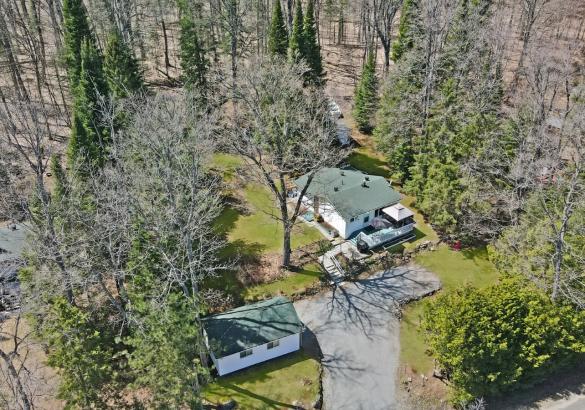 aerial view of a home surrounded by grass and tress.