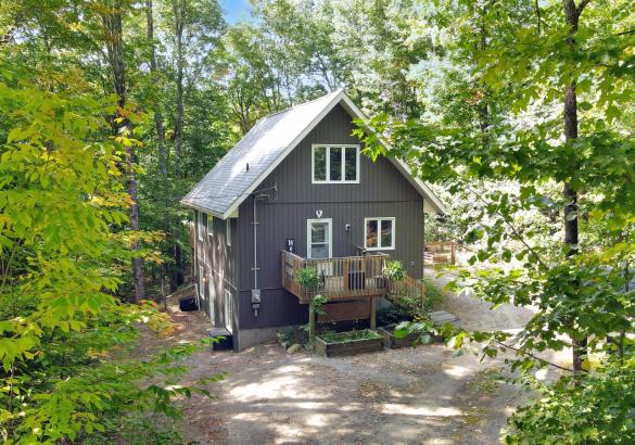 Great house with wood front porch and gravel parking.