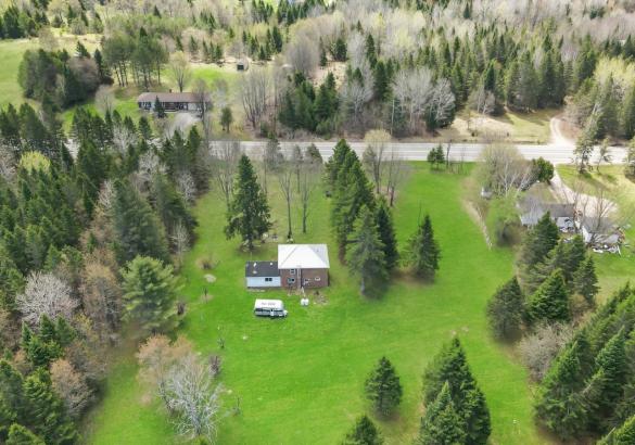 aerial view of a property with green grass and tress around.