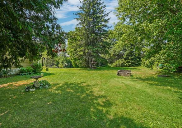 view of green grass, trees, and blue sky