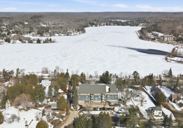 aerial view of a condo building with a frozen lake behind it. 
