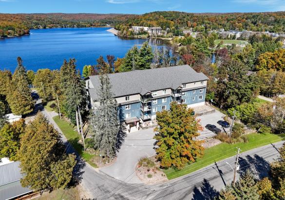 aerial view of a condo building with the lake behind